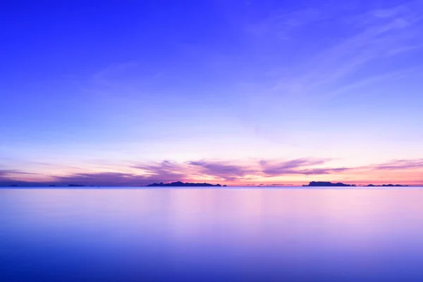 青い海と金色の光の空の雲の背景と美しいビーチの夕日 — ストック写真