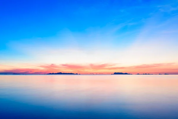 青い海と黄金の光の空の雲の背景と美しいビーチの夕日 長い露出技術 — ストック写真