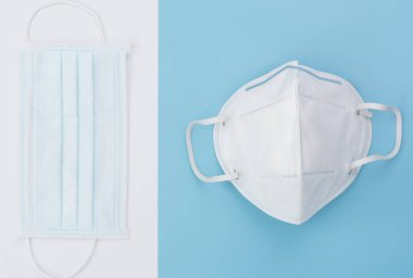 Cerrahi maskeler yumuşak mavi arka planda, düz yatar