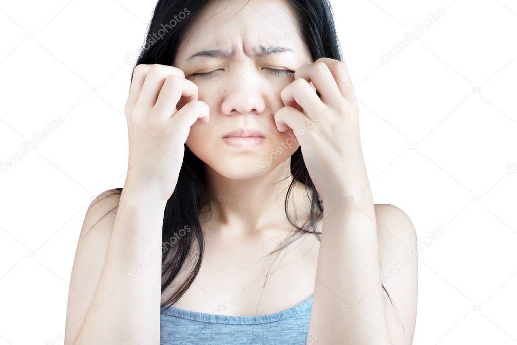 Scratching her face or cheek in a woman isolated on white background. Clipping path on white background.