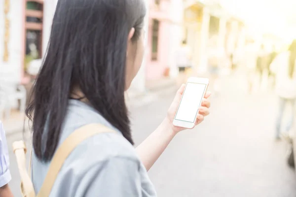 Young Asian traveling blogger or backpacker using route application on the mobile phone  to find the needed address in a city phuket, Thailand. Stock Picture