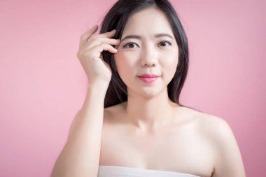 Uzun saçlı Asyalı genç güzel kadın çapraz kol ve parmak yukarıya doğru pembe arka plan üzerinde izole gelin. doğal makyaj, Spa tedavisi, Cilt Bakımı, kozmetik ve plastik cerrahi kavramı.