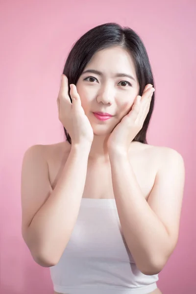 Длинные волосы азиатской молодой красивой женщины скрестить руку и указать пальцем вверх изолированы на розовом фоне. натуральный макияж, СПА-терапия, косметология, косметология и пластическая хирургия . — стоковое фото