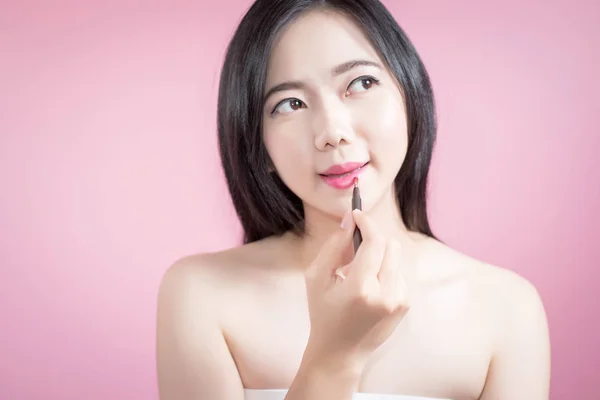 Азиатка наносит розовую помаду на губы, красота лица и натуральный макияж, белый фон изолированы . — стоковое фото