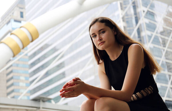 Женщина улыбается портрету и сидит на улице
.