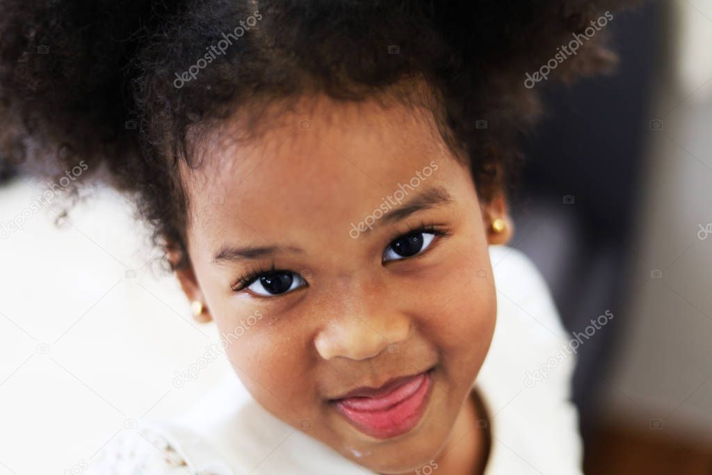 Beautiful African american girl kid smile portrait in home.
