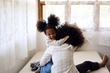 İki Afrikalı kız kardeş tatillerde yatak odasında eğleniyor ve birbirlerine sataşıyorlar..