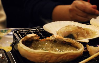 Japonya 'da bir restoranda ızgarada ızgara yengeç ve midye..