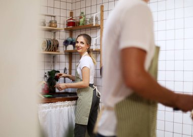 Genç çift gülümseme portresi evdeki mutfak odasında yemek yapmaya hazırlanıyor..