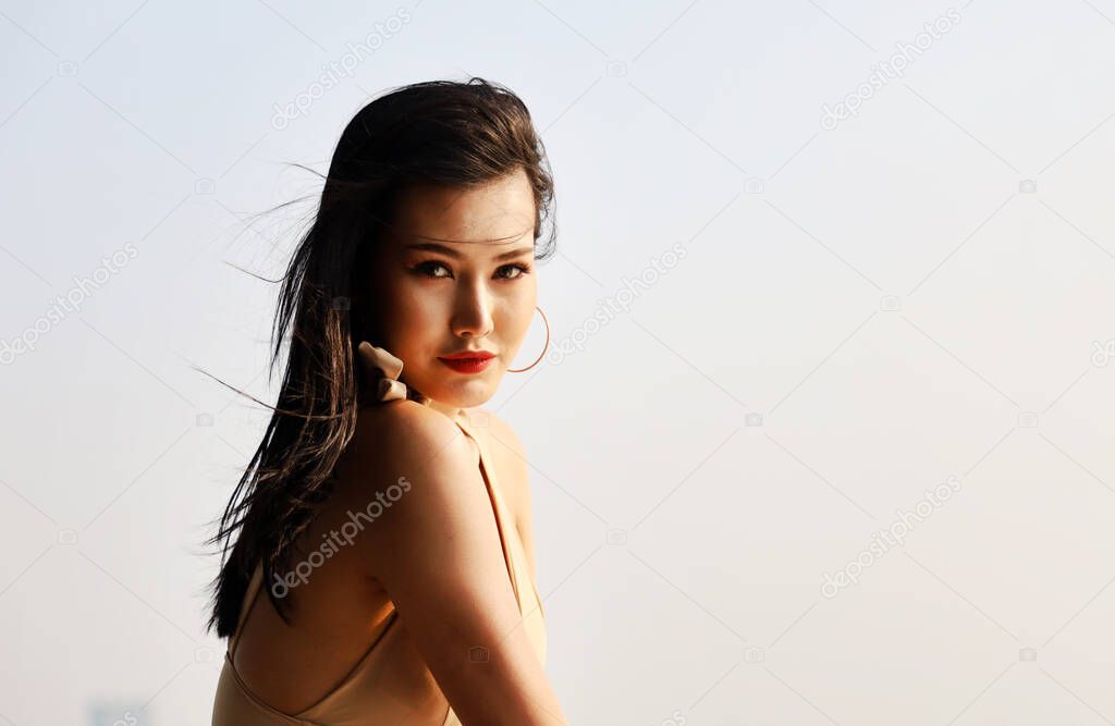 Beautiful Asia woman sexy and smile portrait on beach and soft sunrise on face.