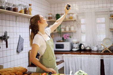 Genç bayan, mutfaktaki çalışma odasında VLOG sosyal medya ve selfie ile canlı yayın yapıyor. COVID-19