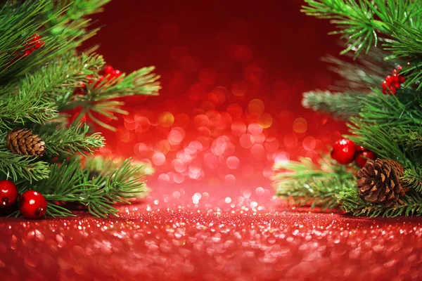 Christmas tree branches on glittering red background — Stock Photo, Image