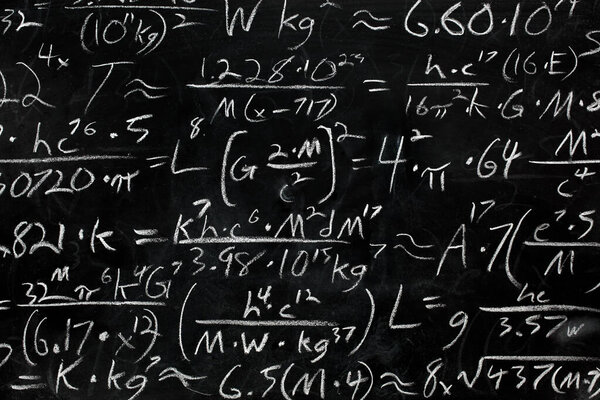 Math equations and formula written in chalk on messy chalkboard 