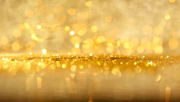 Abstraktes Bokeh aus leuchtend gelben Lichtern und glitzerndem Gold — Stockfoto