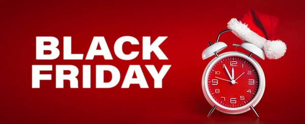 Red clock with Christmas Santa hat and Black Friday text. Time f