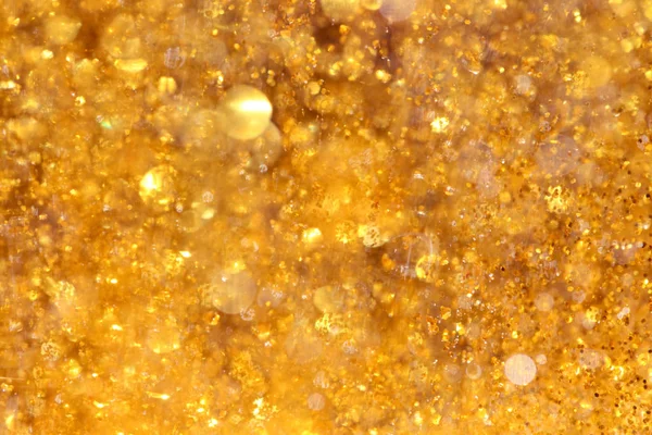 Bokeh abstrato de luzes amarelas brilhantes e brilho ouro cintilante — Fotografia de Stock