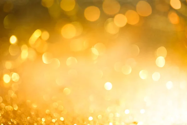 Bokeh abstrato de luzes amarelas brilhantes e brilho ouro cintilante — Fotografia de Stock
