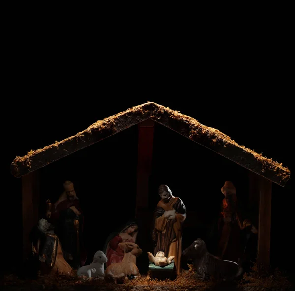 Dimly lit stable showing the Christian nativity scene with the b