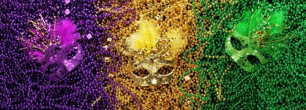 Purple, Ouro, e verde Mardi Gras contas e máscaras de fundo — Fotografia de Stock