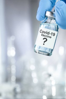 Coronavirus, Covid 19 virüsü ve aşı tüpü içeren mavi eldivenli olası tedavi konsepti.