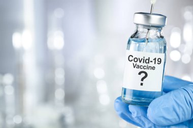 Coronavirus, Covid 19 virüsü ve aşı tüpü içeren mavi eldivenli olası tedavi konsepti.