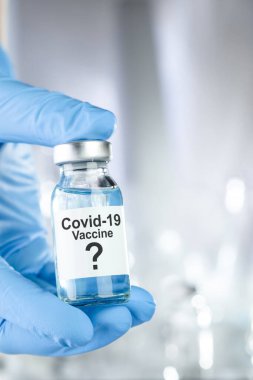 Coronavirus, Covid 19 virüsü ve aşı tüpü içeren mavi eldivenli olası tedavi konsepti.
