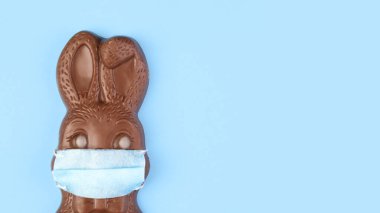 Çikolatalı Paskalya tavşanı Coronavirus 'u korumak için tıbbi maske takıyor.