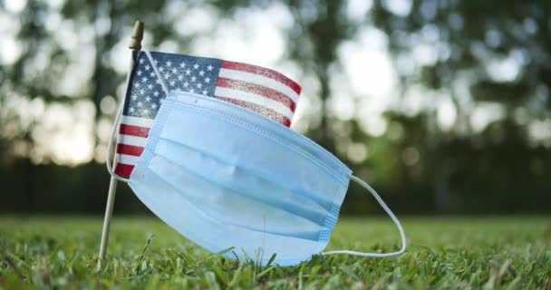 Una Pequeña Bandera Americana Estadounidense Estadounidense Con Mascarilla Quirúrgica Desgastada — Vídeo de stock