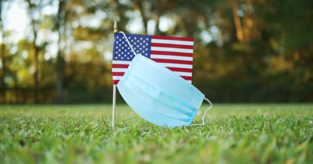 美国或美国的小国旗 戴着外科口罩 随风飘扬显示美国与艾滋病作斗争的理念 — 图库视频影像