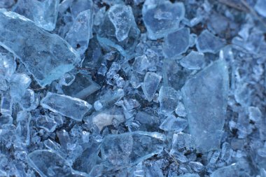 Küçük, keskin cam parçaları ve buz mavisi parçalar.