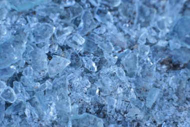 Küçük, keskin cam parçaları ve buz mavisi parçalar.