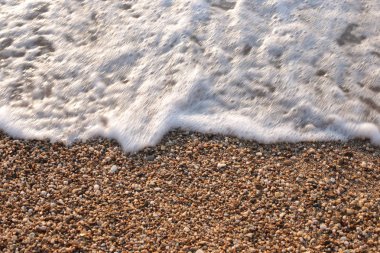 Makro fotoğraf, deniz kenarında küçük çakıl taşları, doğal arka plan.