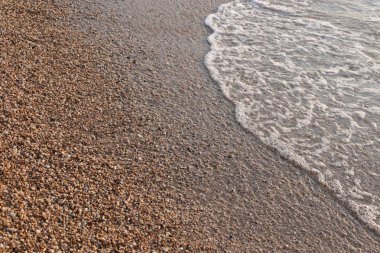 Makro fotoğraf, deniz kenarında küçük çakıl taşları, doğal arka plan.