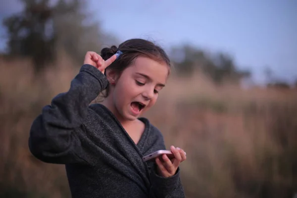 Una Chica Siete Años Con Diferentes Emociones Cara Juega Teléfono — Foto de Stock