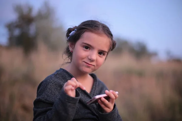 Egy Hét Éves Lány Különböző Érzelmekkel Arcán Játszik Telefonban — Stock Fotó