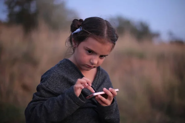 Ein Siebenjähriges Mädchen Mit Unterschiedlichen Gefühlen Gesicht Spielt Telefon — Stockfoto