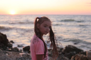 Deniz kıyısında eğlenen komik kız yaz tatillerini neşeyle ve mutlu geçirir.