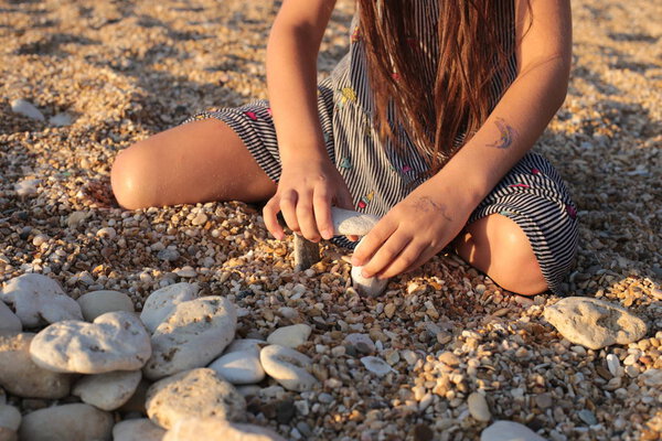 Funny girl frolics on the seashore spending summer vacations joyfully and happily
