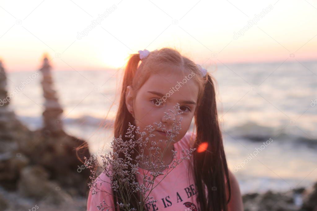 Funny girl frolics on the seashore spending summer vacations joyfully and happily
