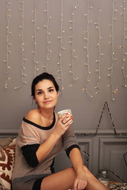 Sıcak kazaklı, zencefilli kurabiye ve bir fincan çayla güzel bir genç kız.