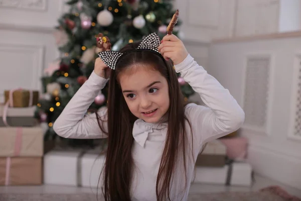 遊び心のある雰囲気の中で長いブロンドの髪を持つ美しい女の子のクリスマスの肖像画は異なる感情を示しています — ストック写真