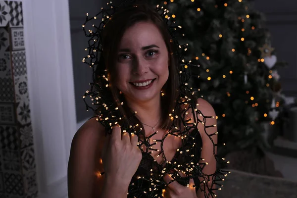 短い暗い髪と美しい女の子ガーランドクリスマスツリーの近くに飾られた — ストック写真