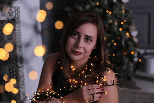 短い暗い髪と美しい女の子ガーランドクリスマスツリーの近くに飾られた — ストック写真