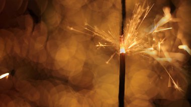 Şenlikli maytap ve bir sürü kıvılcım saçan makro fotoğraf arka planda Noel ve Yeni Yıl