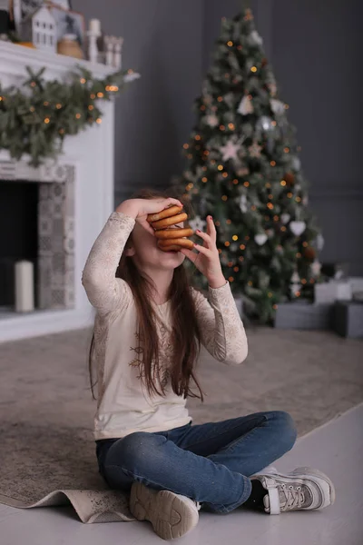 머리의 아름다운 소녀가 크리스마스 트리에서 새해의 조명에 쿠키를 — 스톡 사진