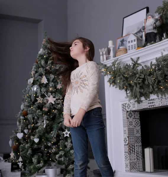 長い暗い髪の美しい女の子は 装飾されたクリスマスツリーで新年のボケのライトでクッキーと一緒に遊んでいます — ストック写真