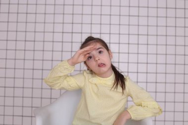 Sekiz yıllık güzel, uzun saçlı, sarı bluzlu, gülümseyen bir kız etrafta aylak aylak dolaşır ve iyi bir ruh hali içinde bir çocuğu buruşturur.