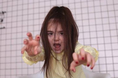 Sekiz yıllık güzel, uzun saçlı, sarı bluzlu, gülümseyen bir kız etrafta aylak aylak dolaşır ve iyi bir ruh hali içinde bir çocuğu buruşturur.