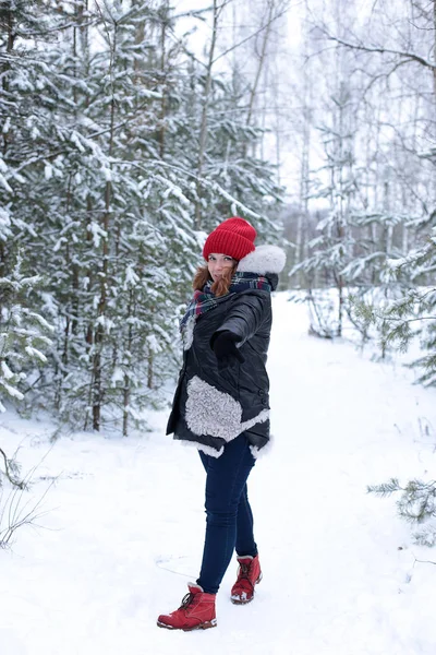 young woman with ginger hair on a winter walk in the forest cold weather and good romantic mood