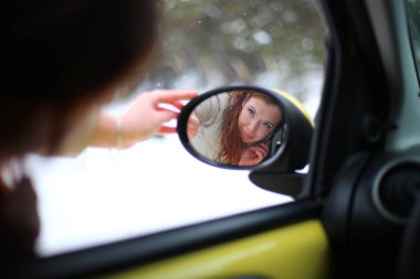Auto lady on a yellow car in a winter landscape